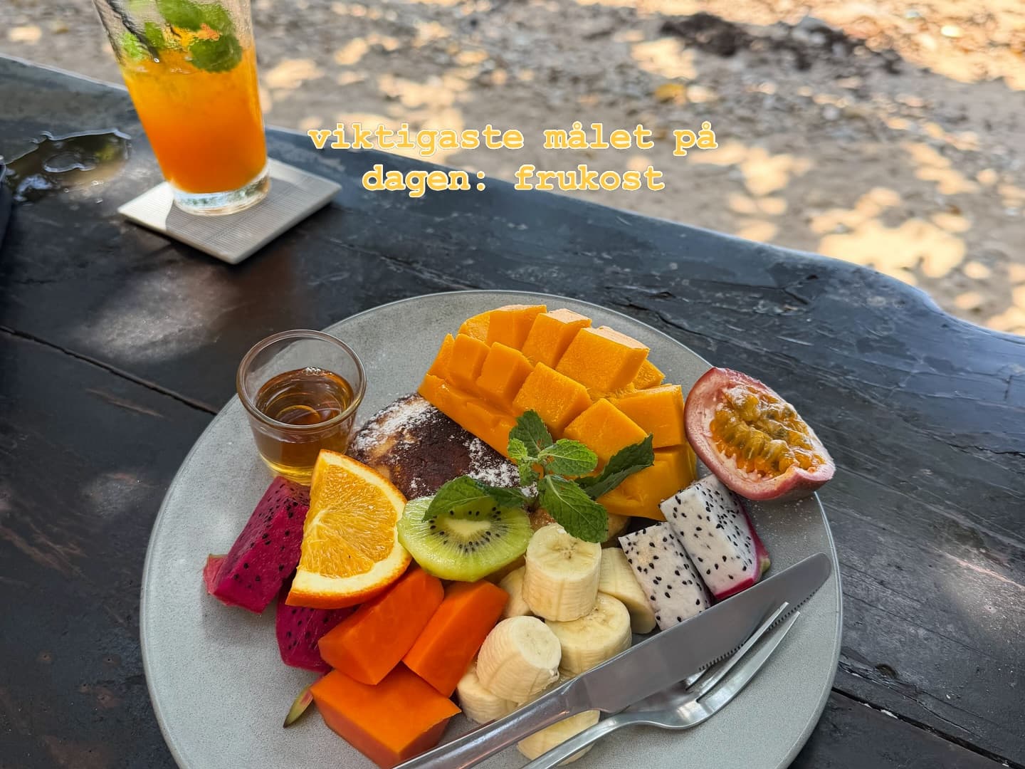 Thai fruit plate with mango, dragonfruit, kiwi, papaya, banana, and passionfruit